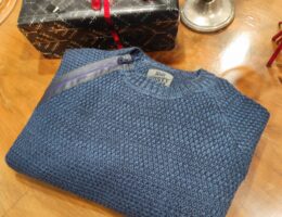 „Dunkelblauer Rusty Neal Herrenpullover aus hochwertigem Baumwoll-Mix, mit strukturiertem Strickmuster und dekorativem Reißverschluss-Detail an der Schulter, präsentiert auf einem Tisch bzw. einer Schaufensterpuppe.“