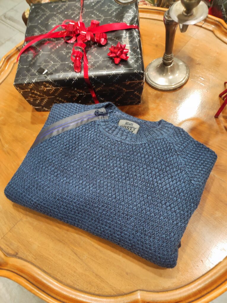 „Dunkelblauer Rusty Neal Herrenpullover aus hochwertigem Baumwoll-Mix, mit strukturiertem Strickmuster und dekorativem Reißverschluss-Detail an der Schulter, präsentiert auf einem Tisch bzw. einer Schaufensterpuppe.“