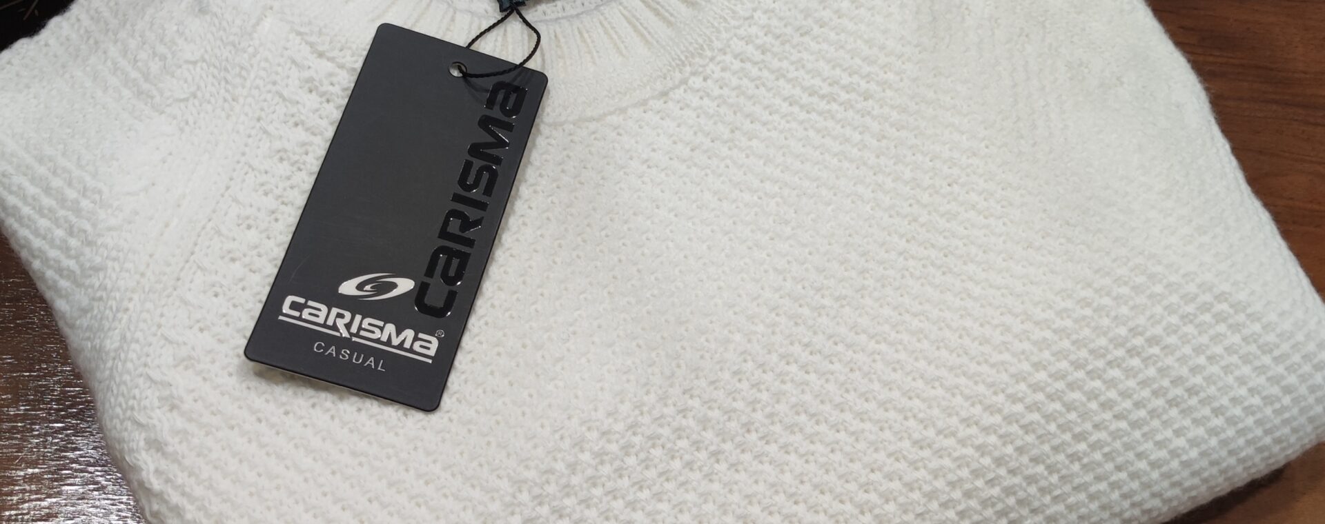 „Weißer Strickpullover auf einer Schaufensterpuppe, mit feiner Struktur und rundem Kragen, kombiniert mit dunkelblauem Hemd.“